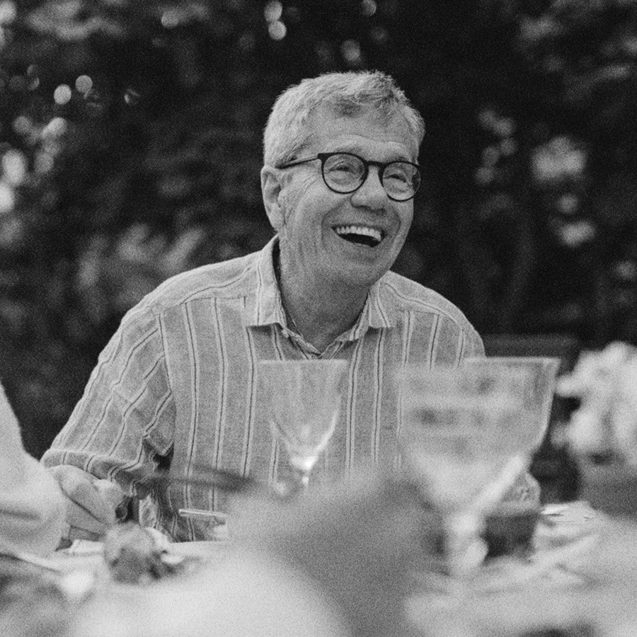 a man smiling at a table with drinks